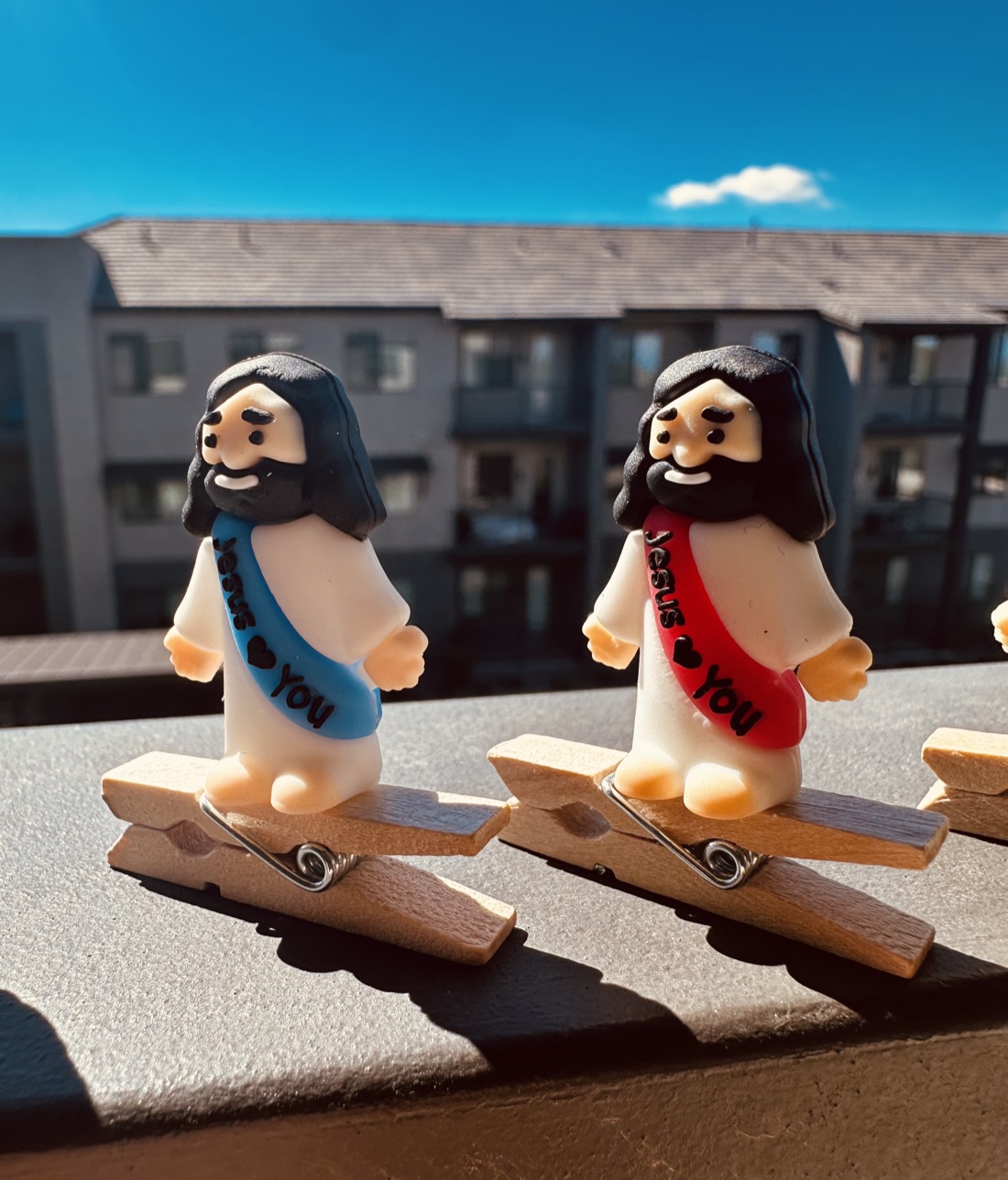 Blue and red sash Clip On Jesus figures on clothespins in the sun