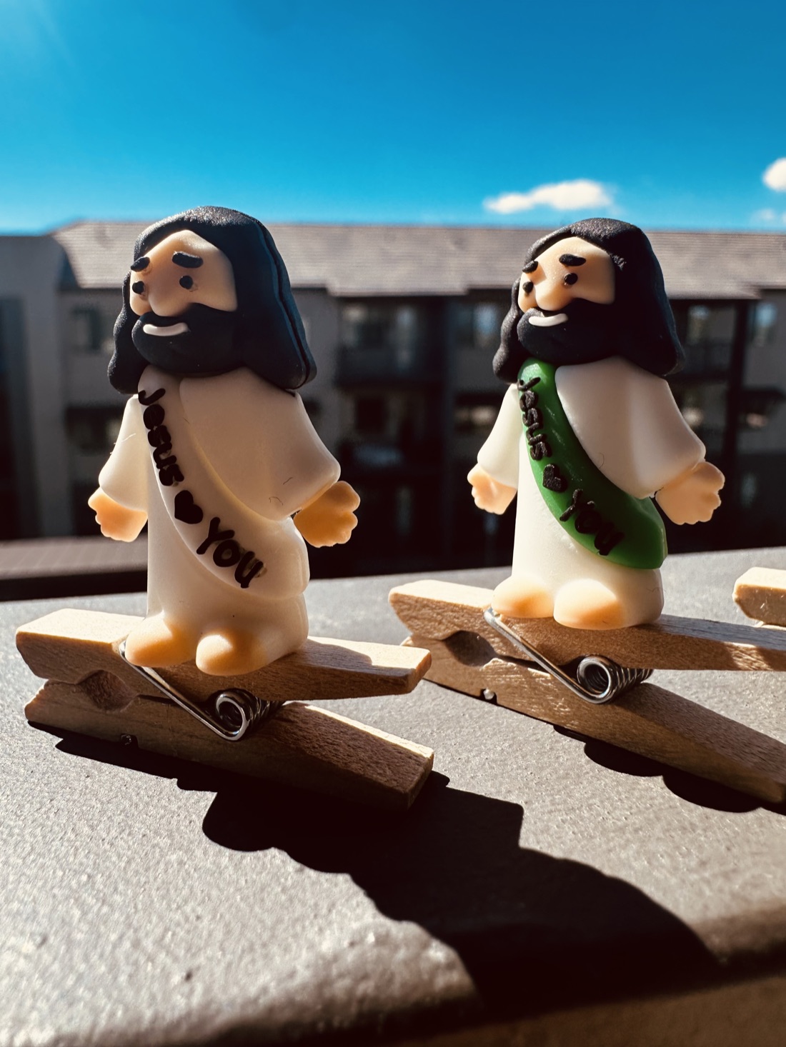 White and green sash Clip On Jesus figures casting long shadows